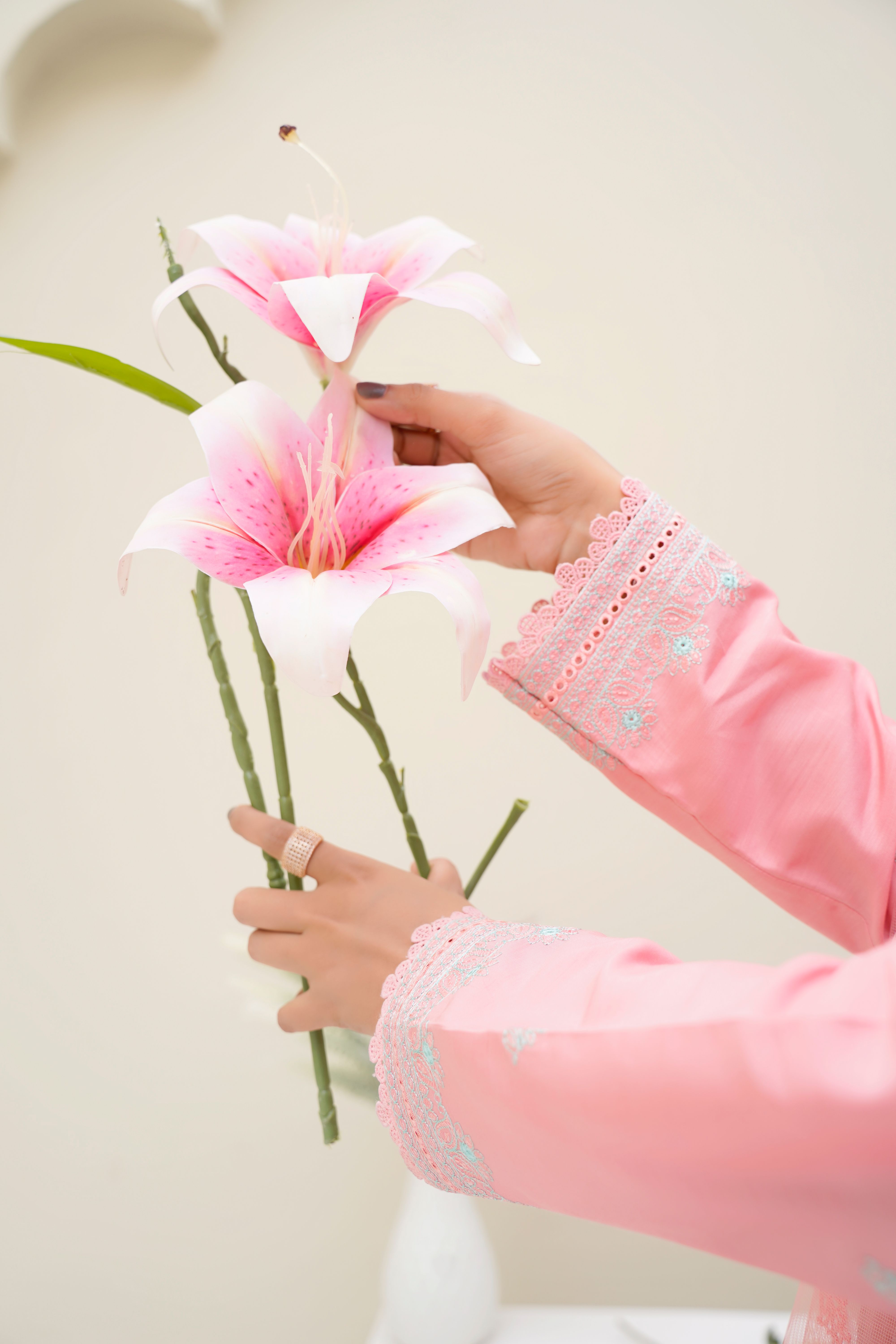 Hands holding delicate pink lilies